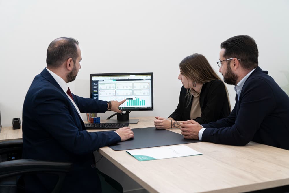 Equipo de ANCORE asesorando a unos clientes para ayudarles a ahorrar en sus servicios